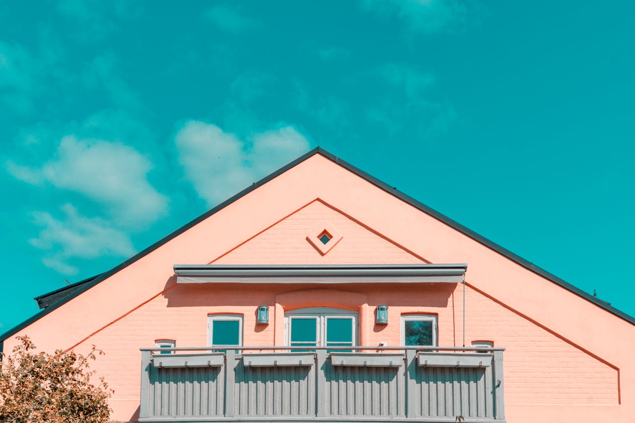 Brightly colored modern house facade with balcony against vivid blue sky in Oslo, Norway.